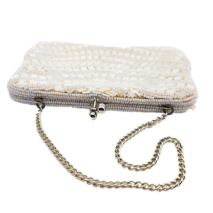 White beaded vintage clutch bag with a chain strap on a white background
