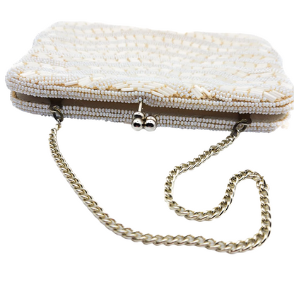 White beaded clutch bag with a chain strap on a white background
